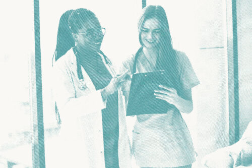 A female doctor and a female nurse talking over a patient's diagnosis with a clipboard