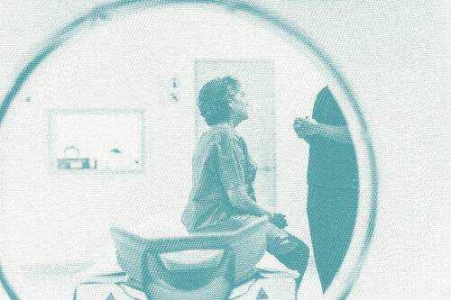 A woman gets ready for an MRI, we see her through the MRI machine